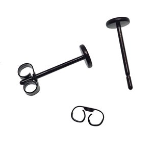 May include: A pair of black stud earrings with a butterfly back closure. The earrings are made of stainless steel and are hypoallergenic.