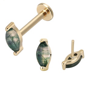 May include: Gold body jewelry with a green agate gemstone. The gemstone is oval shaped and has a marbled pattern.