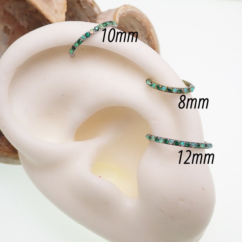 Puede incluir: Tres tama&ntilde;os de anillos de cart&iacute;lago de oreja de &oacute;palo y piedras preciosas verdes. Los anillos tienen un di&aacute;metro de 8 mm, 10 mm y 12 mm.