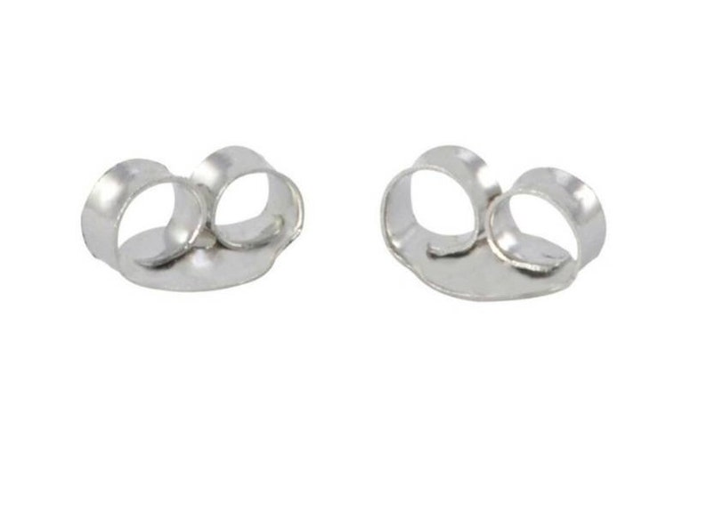 May include: Two silver-colored metal earring backs, each featuring a flat circular base and two curved loops designed to grip an earring post securely. These components are metallic, shiny, and have a smooth, polished finish throughout.