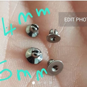 May include: Four small, metallic, silver-colored studs with flat circular bases and rounded tops. Two studs are labeled 4mm and two are labeled 5mm in light blue text. The studs have a reflective finish and a small slit on the top of each rounded head.
