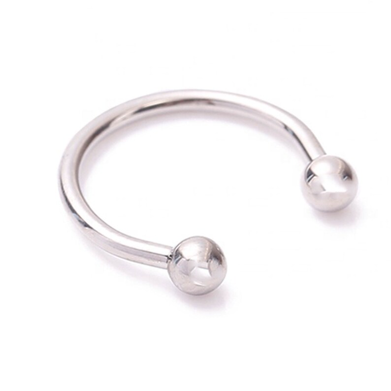 Pu&ograve; includere: Un gioiello a forma di ferro di cavallo di colore argento lucido. Le estremit&agrave; della barra curva terminano con piccole sfere rotonde color argento. Il gioiello &egrave; posto su uno sfondo bianco.
