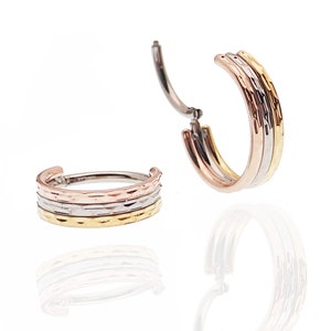 May include: A pair of gold, silver, and rose gold hoop earrings with a hammered texture.