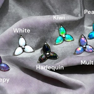 May include: Seven different colors of opalite flower-shaped body jewelry. The colors are white, kiwi, peacock, multi, sleepy, harlequin, and white.