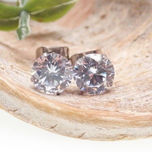 May include: A pair of silver stud earrings with large, clear, round cubic zirconia stones.