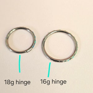 Puede incluir: Dos pendientes de aro con bisagra de plata con detalles de &oacute;palo. El pendiente de la izquierda est&aacute; etiquetado como "18g hinge" y el pendiente de la derecha est&aacute; etiquetado como "16g hinge".