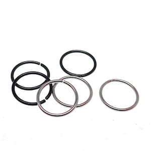 May include: A set of six nose rings, three silver and three black. The rings are all circular and have a simple design.