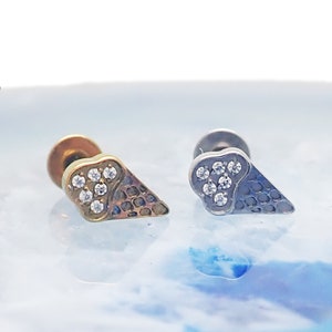 May include: Two gold and silver ice cream cone shaped earrings with clear crystal accents.