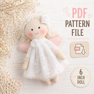 May include: A handmade doll with a white dress and pink wings. The doll has a smiling face with rosy cheeks and a white rose on its head. The text "PDF PATTERN FILE" and "6 INCH DOLL" are also visible.