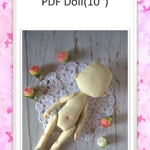 Puede incluir: Un patrón para una muñeca de 25 cm. La muñeca está hecha de tela blanca y está tumbada sobre un encaje blanco. La muñeca está rodeada de pequeñas flores rosas.