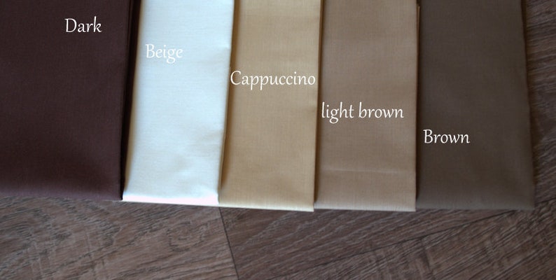May include: Five fabric swatches in different shades of brown, from dark brown to beige. The swatches are labeled "Dark", "Beige", "Cappuccino", "light brown", and "Brown".