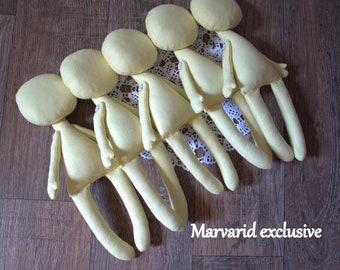 May include: Five unfinished yellow fabric dolls lined up on a white lace doily. The dolls are all the same size and shape, with simple features and long limbs. The dolls are arranged in a row, with their heads facing the same direction. The dolls are on a wooden surface. The text "Marvarid exclusive" is visible in the lower right corner of the image.