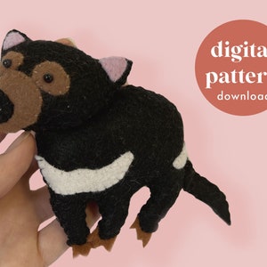 May include: A digital pattern download for a felt Tasmanian devil plush toy. The pattern includes instructions for sewing a black and white felt toy with brown ears and black eyes.