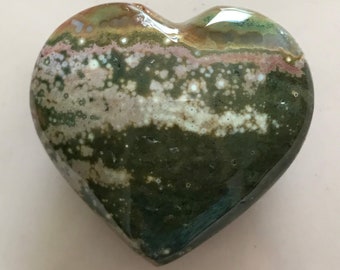 May include: A heart-shaped green, brown, and white stone with a mottled pattern.