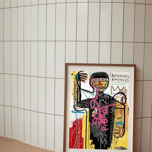 Puede incluir: Una impresi&oacute;n art&iacute;stica enmarcada con una obra de arte de Jean-Michel Basquiat. La impresi&oacute;n muestra una figura con un contorno negro, un torso rosa y un fondo amarillo y rojo. El nombre del artista est&aacute; impreso en la parte inferior.