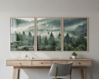 Op de afbeelding: Een drieluik van ingelijste wandkunst met een dicht, mistig boslandschap met groenblijvende bomen in diepgroene en grijze tinten. De drie rechthoekige lijsten zijn horizontaal gerangschikt en tonen een doorlopend beeld van de mist.