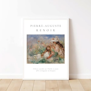 Puede incluir: Impresi&oacute;n art&iacute;stica enmarcada en blanco que presenta una pintura de Pierre-Auguste Renoir. La obra de arte representa a dos ni&ntilde;as en un campo de flores, con texto en la parte superior e inferior de la impresi&oacute;n. La impresi&oacute;n se muestra en una pared blanca sobre un suelo de madera.