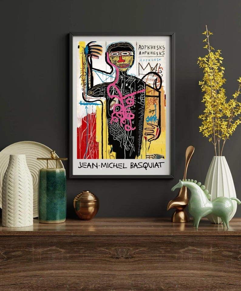 Puede incluir: Impresi&oacute;n art&iacute;stica enmarcada que presenta una obra de arte de Jean-Michel Basquiat. La impresi&oacute;n muestra una figura negra con una estructura interna rosa, una corona y el nombre del artista. El fondo incluye trazos de pintura amarillos, rojos y blancos.