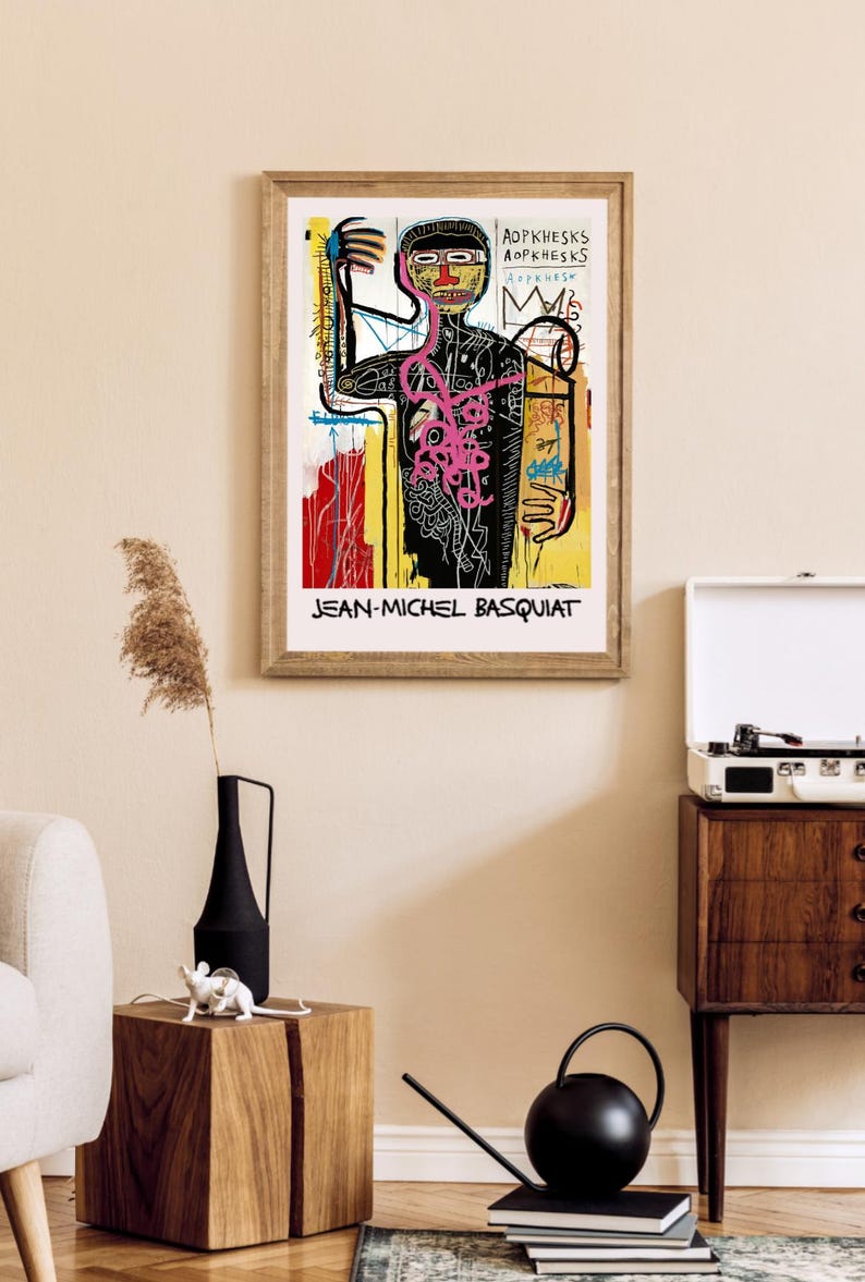 Puede incluir: Impresi&oacute;n enmarcada de una obra de arte de Jean-Michel Basquiat. La obra representa una figura estilizada con l&iacute;neas audaces y colores vibrantes, con el nombre del artista en la parte inferior. La impresi&oacute;n est&aacute; en un marco de madera.