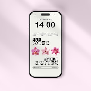 May include: A smartphone screen displaying the time 14:00, the date Thursday 4 July, and the text "Expect Nothing, Appreciate Everything". The screen also features three pink flowers.