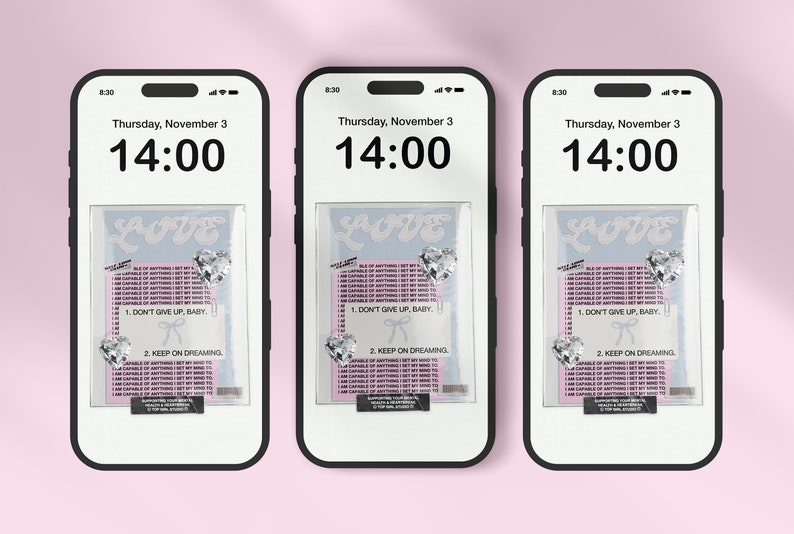 May include: Three identical smartphone screens displaying a digital clock with the time 14:00 and the date Thursday, November 3. Each screen also shows a phone case with a clear plastic cover and a pink and blue design with the word "LOVE" and the text "1. DON'T GIVE UP, BABY" and "2. KEEP ON DREAMING".