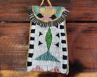 May include: A beaded Native American pouch with a fringe of metal cones. The pouch is decorated with black, white, pink, green, and blue beads in a geometric pattern.