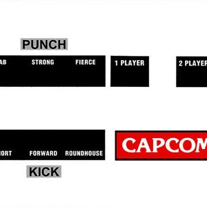 May include: A black and white control panel for the Street Fighter 2 Champion Edition video game. The panel features a circular control pad with directional arrows and buttons for punch and kick. The text "CAPCOM" is displayed in red.