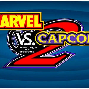 May include: A video game arcade cabinet with a blue background and a yellow, red, and black logo that reads "MARVEL VS. CAPCOM 2". The cabinet features characters from the Marvel and Capcom universes, including Captain America, Wolverine, and Ryu.