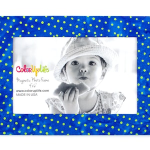 May include: A blue and yellow polka dot magnetic photo frame, with a 4x6 inch opening, displays a black and white photo of a child. The frame has the text "ColorUpLife" and "Made in USA".