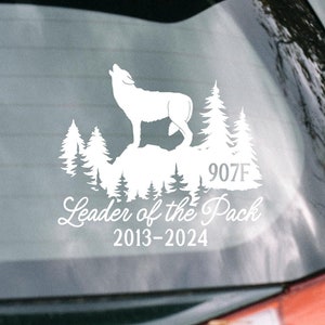 May include: White decal featuring a howling wolf silhouette atop a rocky landscape with pine trees. Text includes "Leader of the Pack" and the years "2013-2024". The decal also has the number "907F".