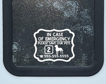 May include: White sticker on a window of a camper van that says "In case of emergency please save our pets" with a silhouette of a dog and the number 2 and a phone number.