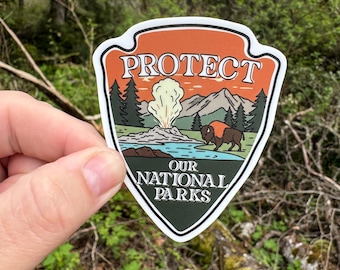 May include: A sticker with a green, orange and white design. It features a geyser erupting, a bison and mountains. The text "PROTECT OUR NATIONAL PARKS" is written in white on a green background.