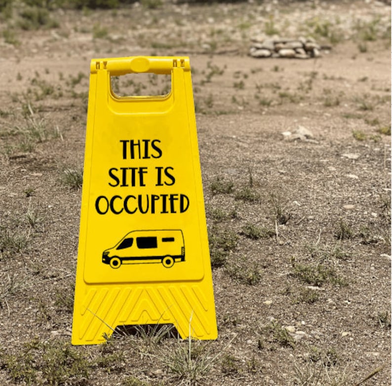 May include: Yellow and black caution sign with the text "This Site Is Occupied" and a black silhouette of a van.