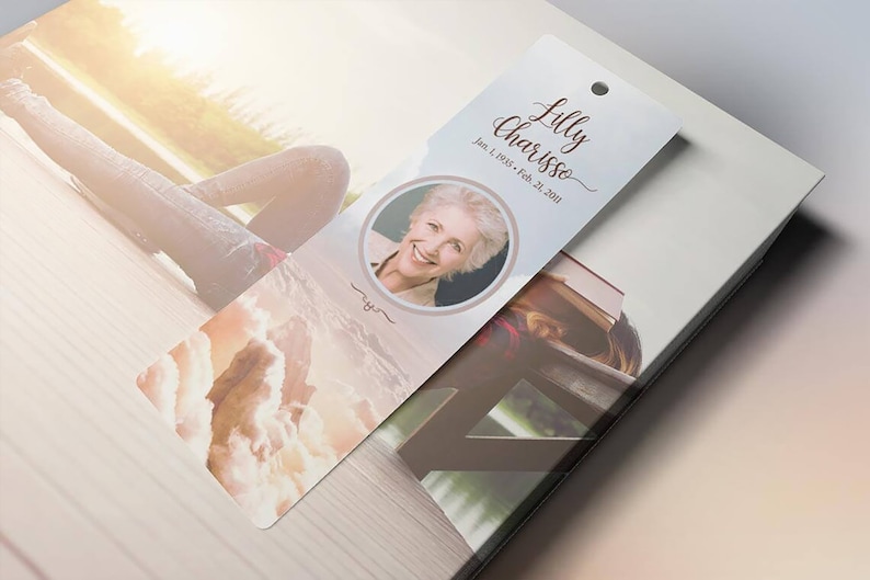 Heaven Memorial Bookmark Template for Word and Publisher is 2.5x7.75 inches. The beige, pink, and blue sunrise background with a praying hand and a dove makes this a great funeral keepsake to remember your loved one. The memory card is designed for