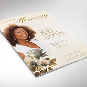 May include: A memorial service booklet featuring a photograph of a woman with curly hair. The booklet is adorned with white roses and gold accents. The text on the booklet reads "In Loving Memory Mary Olivia Jackson Sept 5, 1950 - Mar 14, 2023" and "May 20, 2023 @ 10AM Lindell Hill Church 150 Mars St. Winsor, CA".