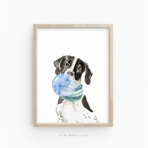 May include: Watercolor painting of a black and white dog wearing a blue and green scarf and blowing a blue bubble. The dog is looking at the viewer. The painting is framed in a light wood frame.