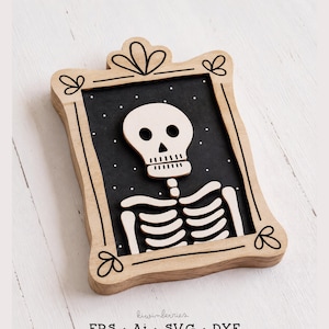 May include: A wooden wall plaque featuring a light-colored wooden frame with black line art details. Inside the frame is a black background with white dots and a light-colored wooden skeleton cutout. The text reads kiwinberries EPS Ai SVG DXF.
