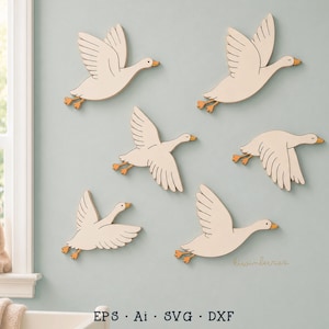 May include: Six cream-colored wooden goose wall decorations in various flying poses, each featuring orange beaks and feet. The geese are arranged in a flock formation. The text "kiwinberries" is printed in small script, and "EPS Ai SVG DXF" is at the bottom.
