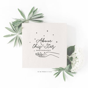 May include: A minimalist logo design with the text "Above this Star Photography" in a cursive font. The logo features a hand reaching up towards a cluster of stars.