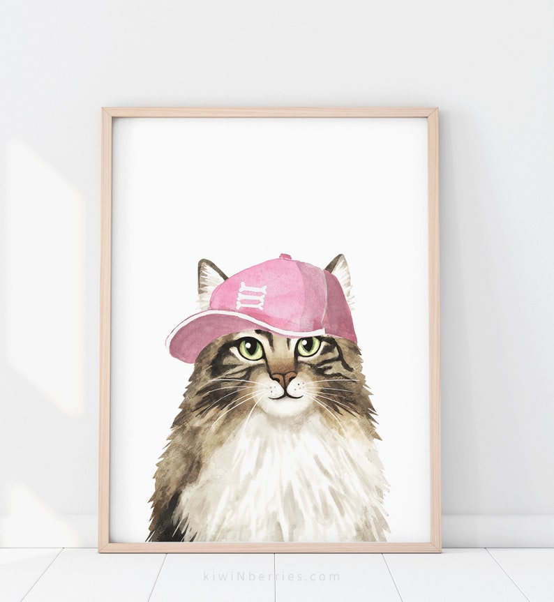 Puede incluir: Una pintura de acuarela de un gato con una gorra de b&eacute;isbol rosa con el n&uacute;mero "III" en ella. El gato tiene pelo marr&oacute;n y blanco y ojos verdes.