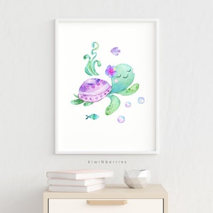May include: A watercolour painting of a green sea turtle with a purple and pink shell, swimming with bubbles and a small fish. The turtle has a pink flower on its head and closed eyes. The painting is framed in a white frame.