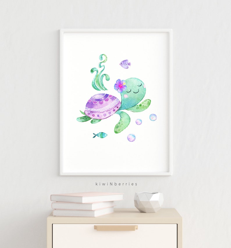 May include: A watercolour painting of a green sea turtle with a purple and pink shell, swimming with bubbles and a small fish. The turtle has a pink flower on its head and closed eyes. The painting is framed in a white frame.