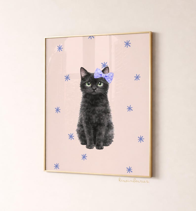 May include: A framed art print featuring a black cat with a blue bow, set against a pink background adorned with blue snowflake designs. The cat has green eyes and a fluffy coat. The frame is gold.