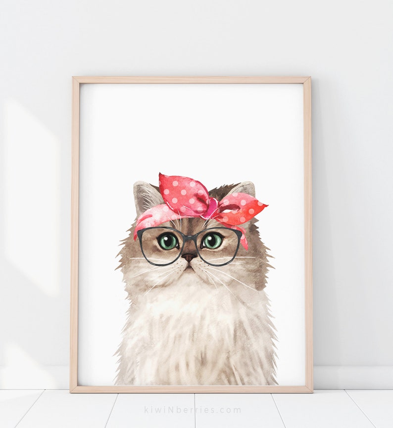 Puede incluir: Una pintura de acuarela de un gato con un pa&ntilde;uelo de lunares rosa y blanco y gafas redondas. El gato tiene un pelaje marr&oacute;n claro y blanco y ojos verdes.