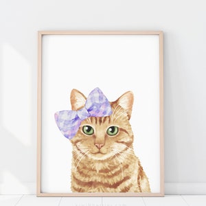 Puede incluir: Una pintura de acuarela de un gato jengibre con un lazo morado y rosa. El gato tiene ojos verdes y mira directamente al espectador. El fondo es blanco.