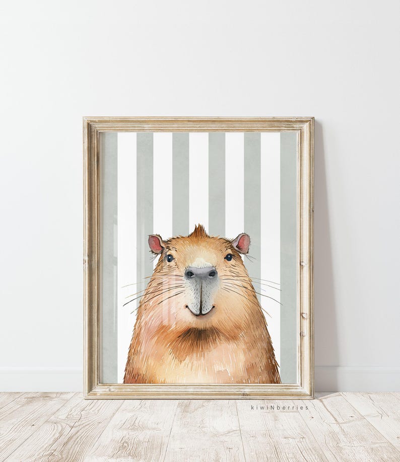 May include: A watercolour illustration of a capybara with a striped background. The capybara is looking directly at the viewer with a friendly expression. The illustration is framed in a light wood frame.