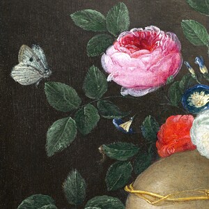 May include: A close-up of a still life painting featuring a skull with a gold crown, surrounded by pink, red, and white flowers, green leaves, and a white butterfly.