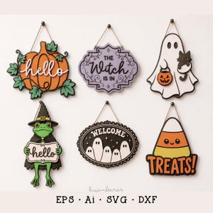 May include: Six decorative Halloween-themed wooden wall signs with twine hangers. Designs include an orange pumpkin with 'hello', a purple sign reading 'THE Witch IS IN', a white ghost with a black cat, a frog in a hat holding 'hello', a black oval sign with 'WELCOME' and ghosts, and a candy corn with 'TREATS!'.