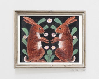 Op de afbeelding: Twee bruine konijnen die elkaar aankijken, met witte accenten, op een zwarte achtergrond met groene bladeren en witte bloemen.