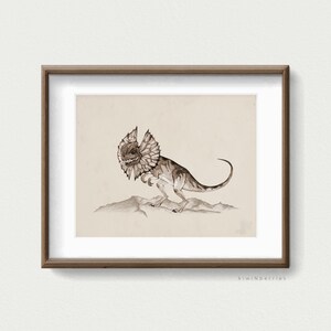 May include: A framed print of a watercolour illustration of a frilled lizard, a type of dinosaur, in a desert setting. The lizard is brown and has a frill around its neck. The background is a light brown colour.